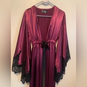 long magenta satin widows robe with black lace sleeves and black bel
